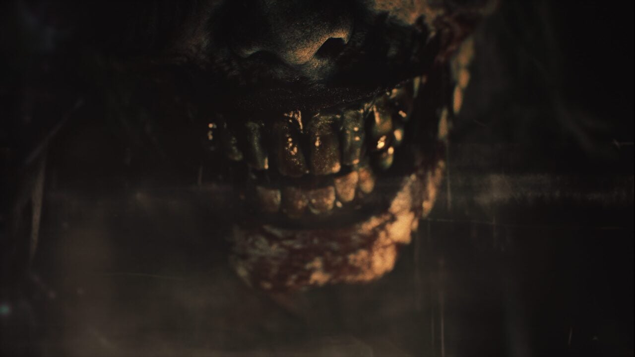 Close-up of a creature's mouth with sharp teeth in a dark, foggy setting