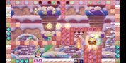 A colorful screenshot from a platformer game showing a whimsical candy-themed level with characters, blocks, and UI elements.