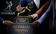Heisman Trophy being held by a person with the Heisman logo in the background