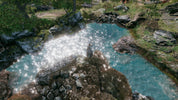 Stream of water flowing over rocks with a natural landscape background