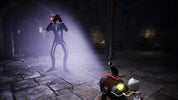 A dark, atmospheric video game scene showing a tall cloaked humanoid figure with a glowing red head in a stone corridor, while a small character with white hair stands beside a red and black device with a glowing yellow light in the foreground.