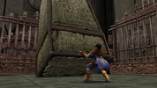 A video game scene showing a small character in a blue and purple outfit pushing a large stone pyramid with ancient carvings in a stone chamber with ornate metal gates.