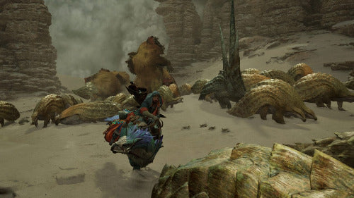 A fantasy scene showing a rider on a blue and red creature or mount moving through a rocky desert canyon filled with armored dinosaur-like monsters.