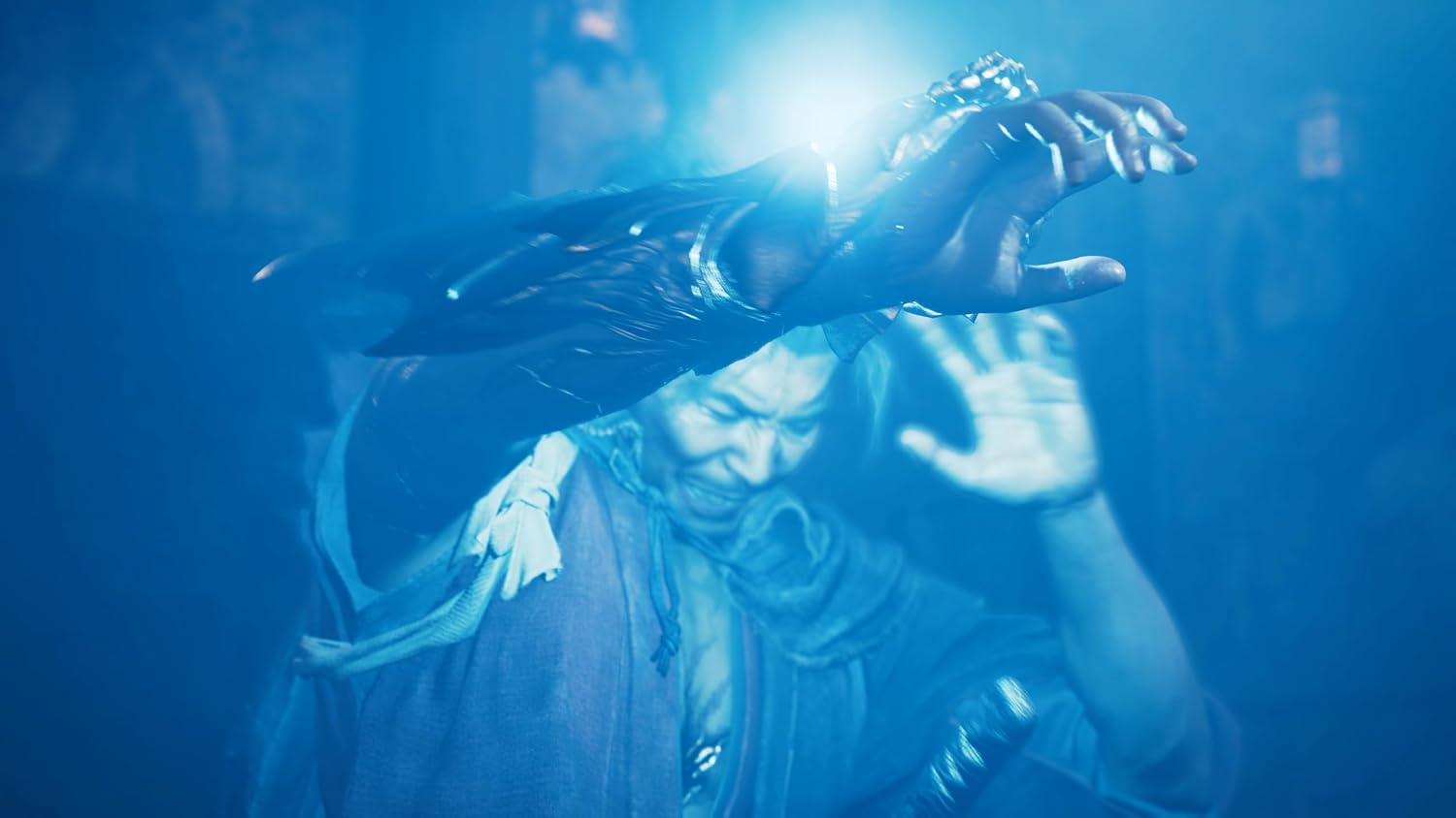 A dramatic blue-lit scene showing a person in dark clothing with glowing hands and a bright light source between them, set against a dark atmospheric background.