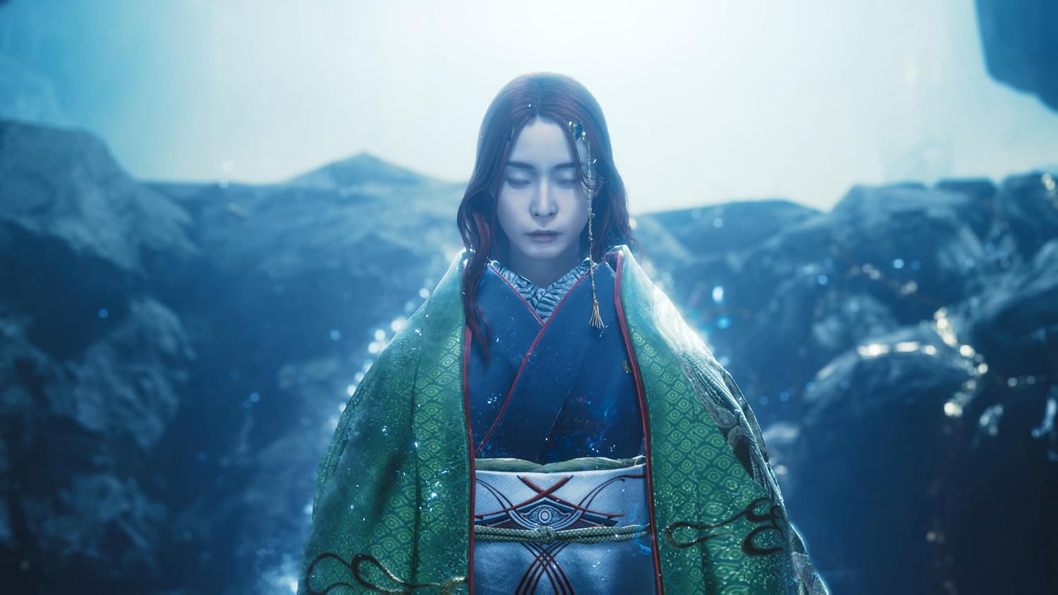 A person in ornate traditional-style clothing stands centered in a misty, rocky outdoor setting. The garment is predominantly green with blue, white, and red details, and the background is cool-toned and atmospheric.