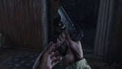 A close-up shot of a person's hands holding a black semi-automatic pistol in a dimly lit, rustic indoor setting.