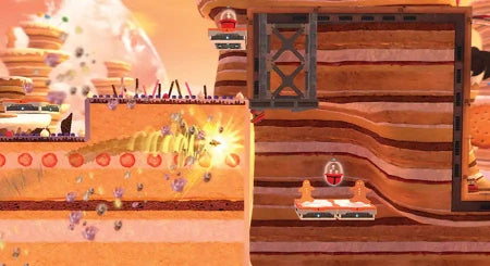 A stylized 2D platformer scene with layered tan and brown terrain, glowing yellow light effects, floating red circular elements, and small character-like figures in a surreal landscape.