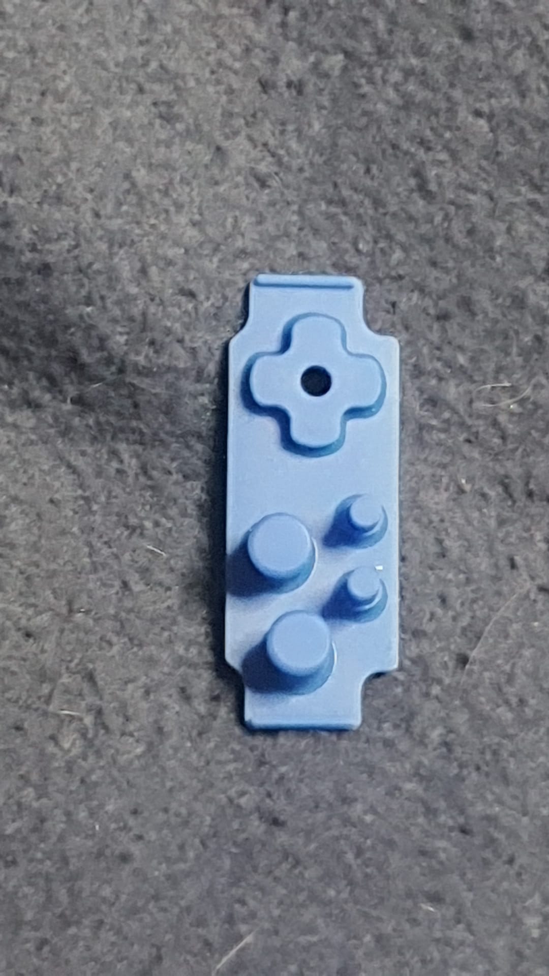 Blue plastic component on a gray surface