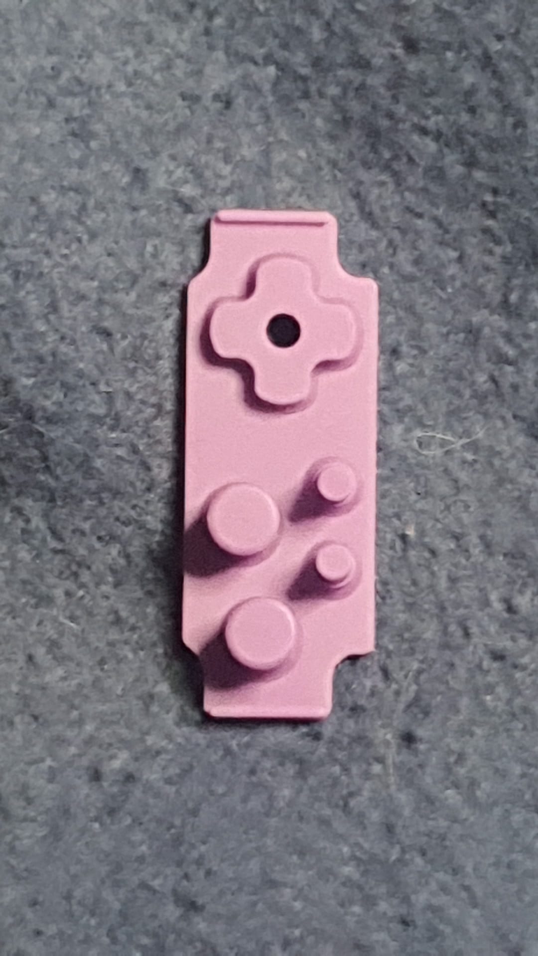 Pink building block piece on a gray surface