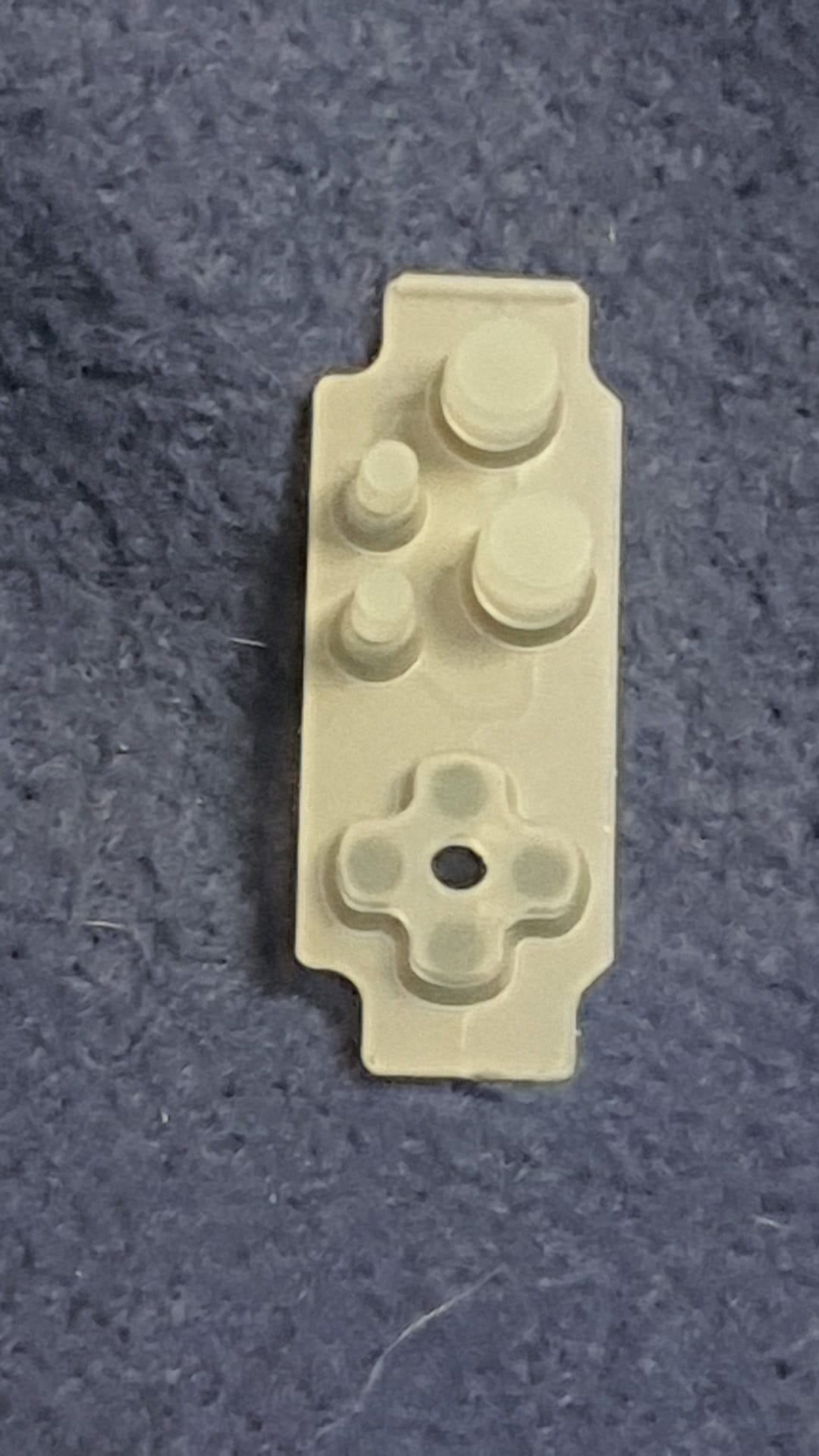 White plastic component on a textured gray background