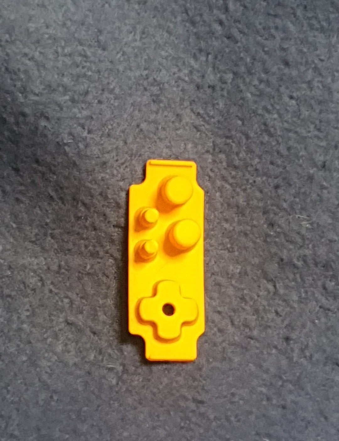 Yellow toy brick on a gray surface