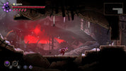 Dark and atmospheric scene from a video game with a character in a dark room with red glowing elements.